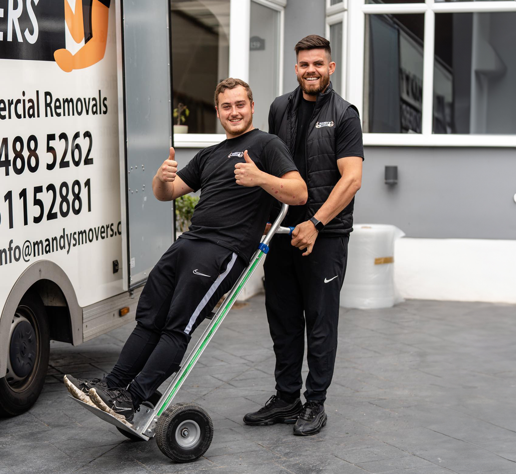 Two men from mandys movers outside house