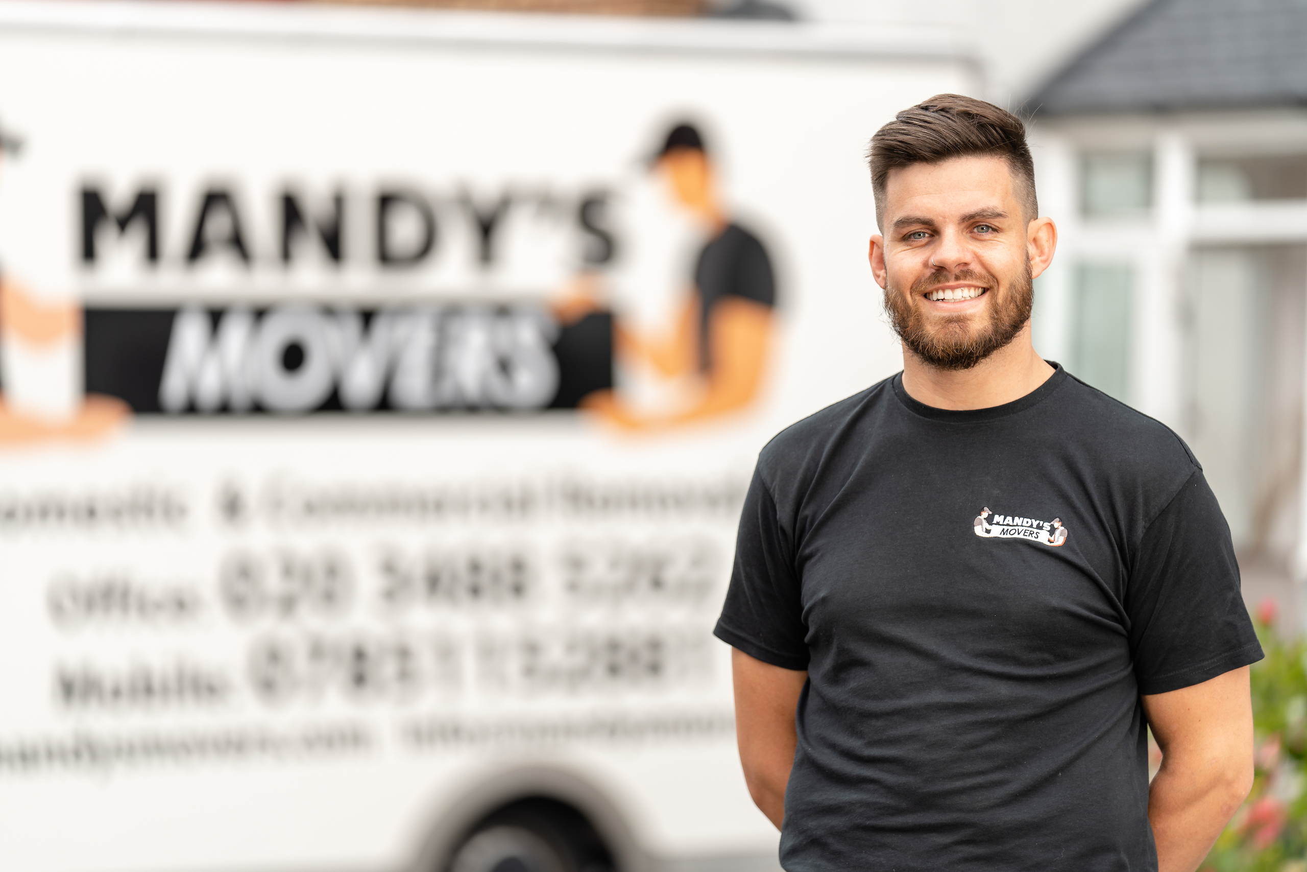 Ben from mandys movers standing next to a blurred mandys movers van